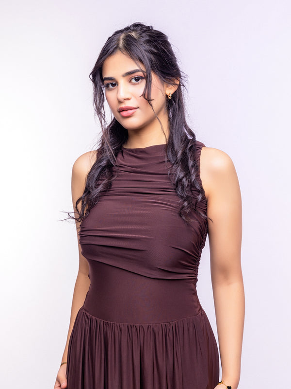 Woman wearing a brown sleeveless top and skirt against a white background