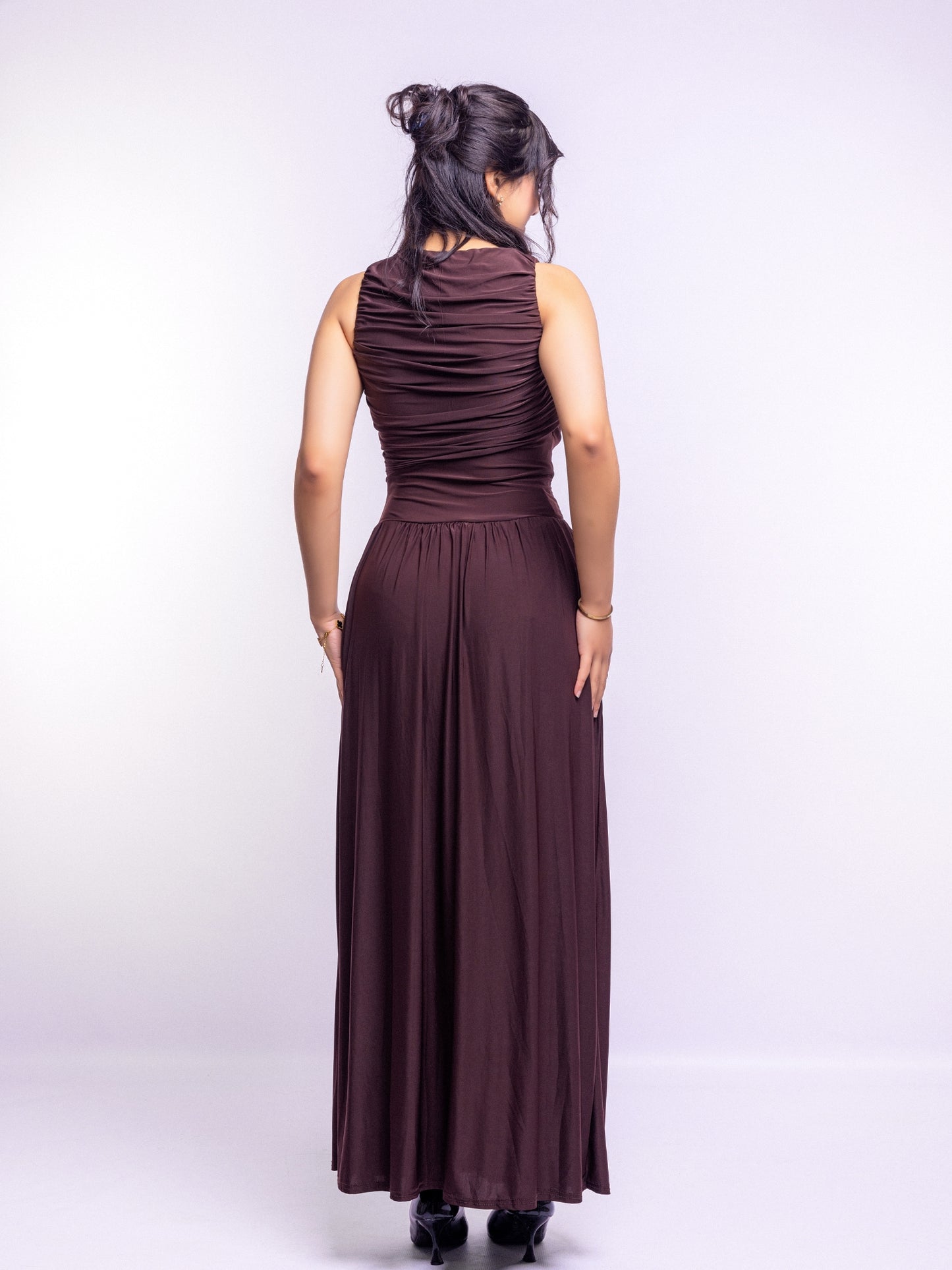 Woman wearing a long brown dress on a white background