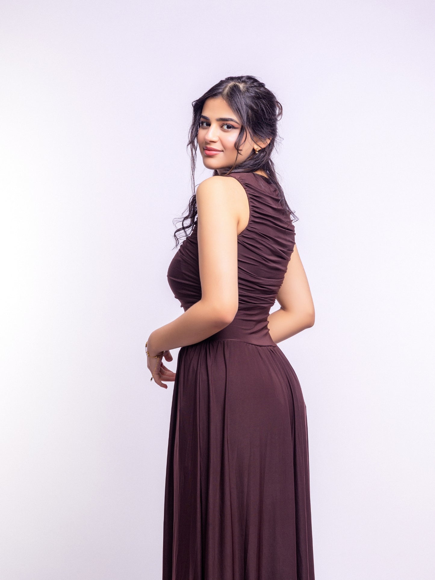 Woman wearing a brown dress against a white background