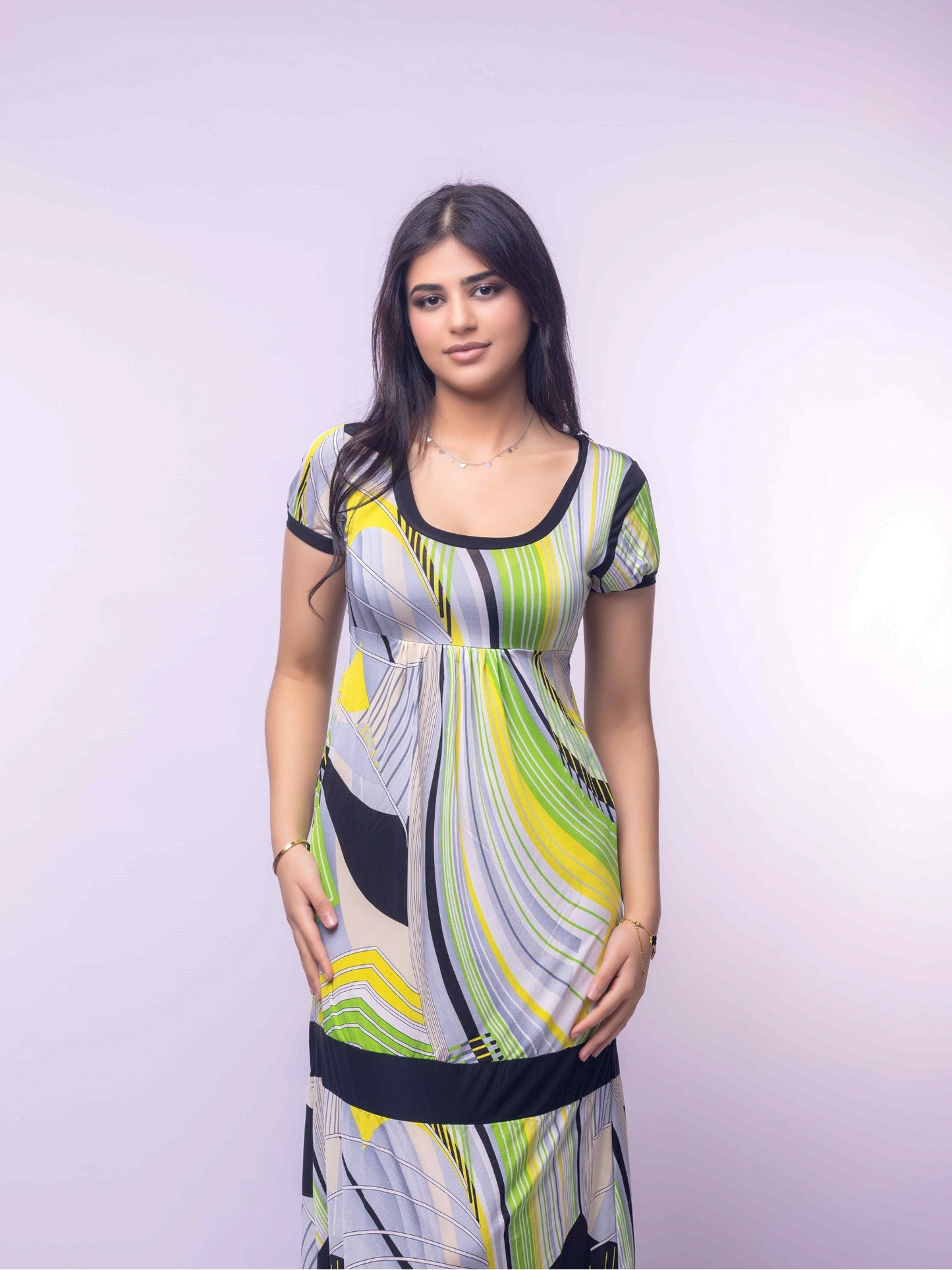 Woman wearing a colorful dress against a plain background