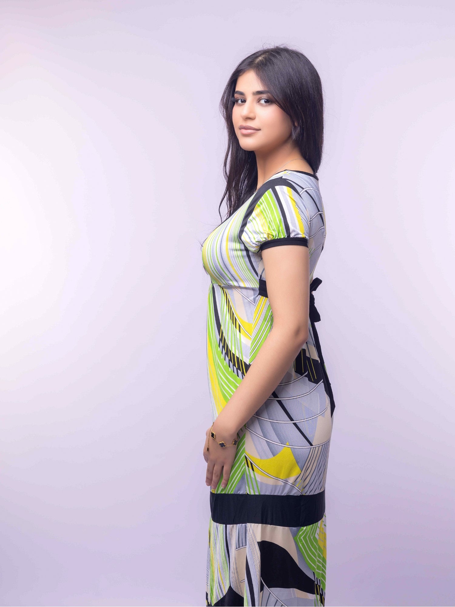 Woman wearing a colorful dress with abstract patterns on a light gray background