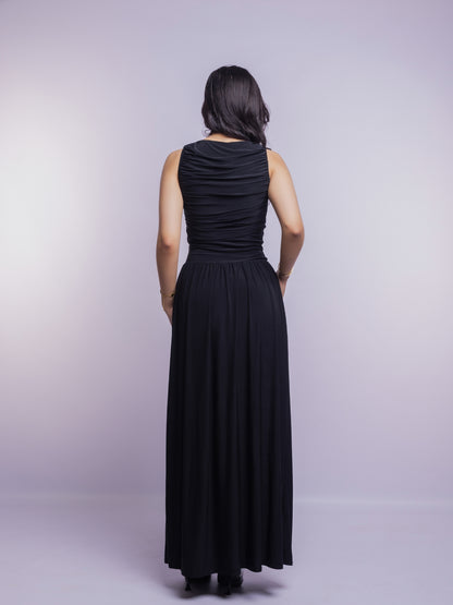 Woman wearing a black sleeveless dress against a plain background