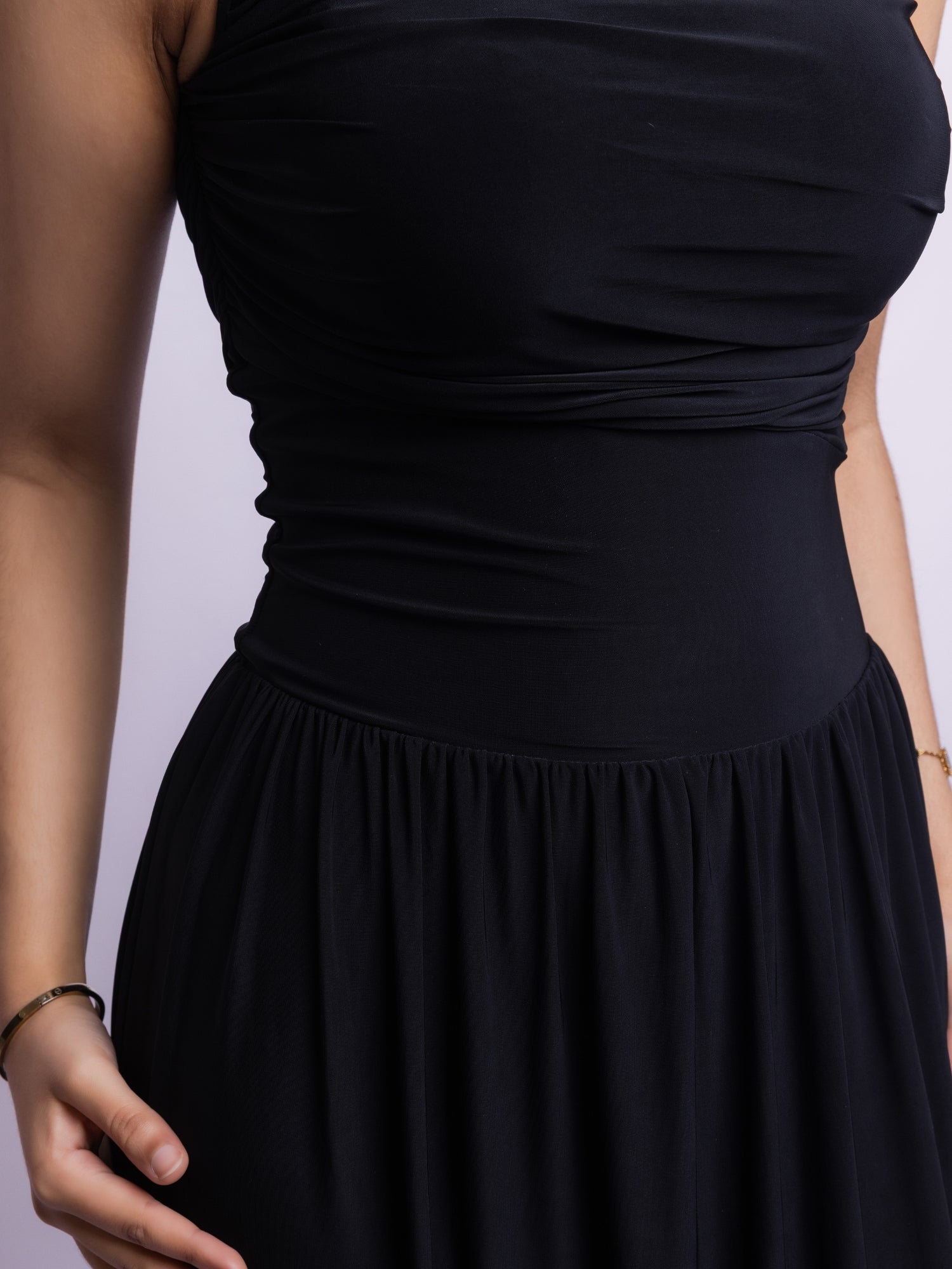 Black dress on a mannequin against a light purple background