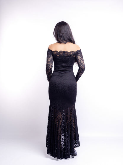 Woman wearing a black lace off-shoulder dress against a white background