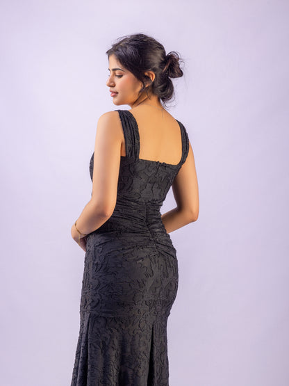 Woman wearing a black lace dress against a light purple background