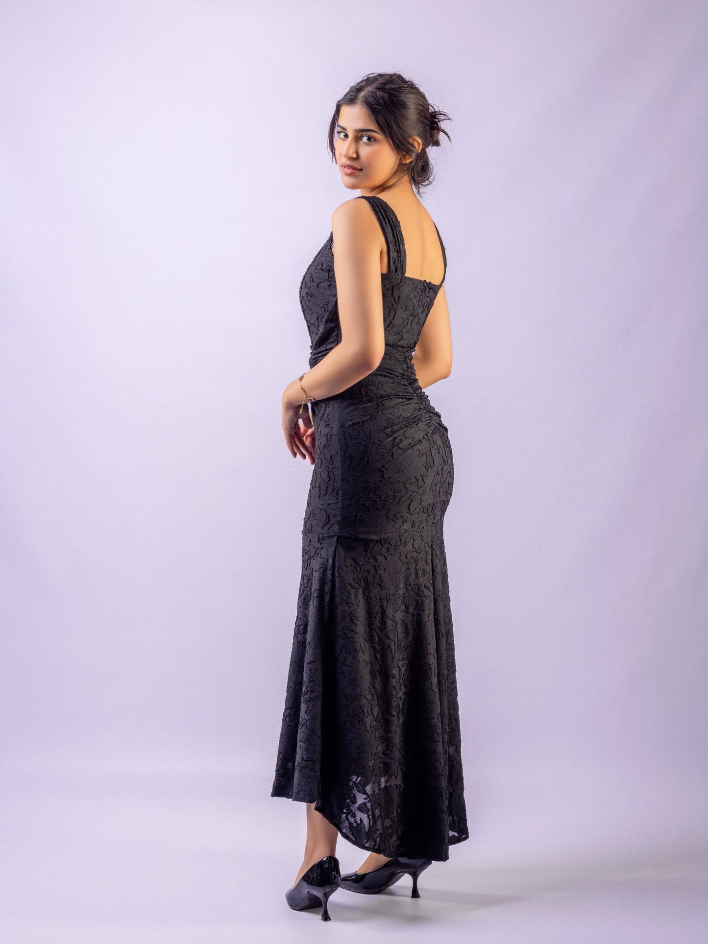 Woman wearing a black evening gown against a white background