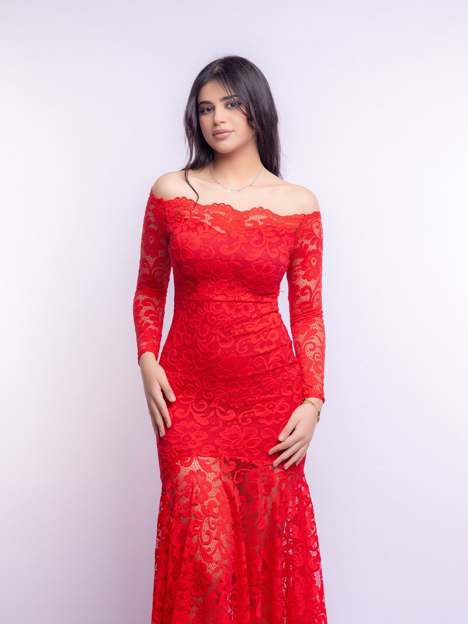 Woman wearing a red lace dress against a white background
