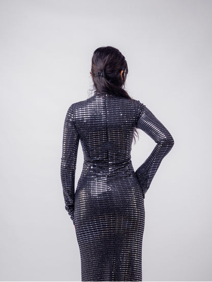 Person wearing a black sequin dress against a white background