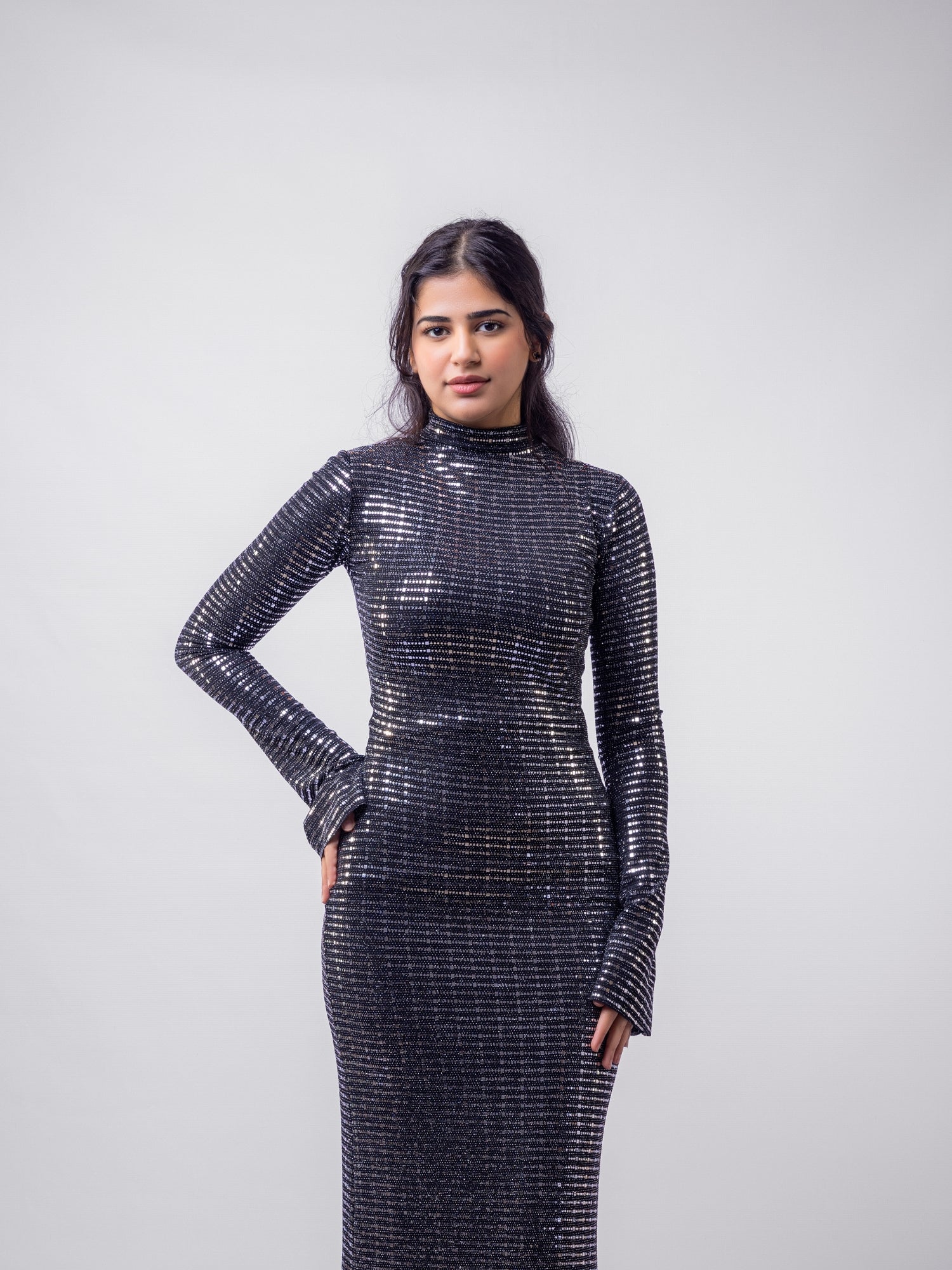 Woman wearing a black sequin dress against a white background