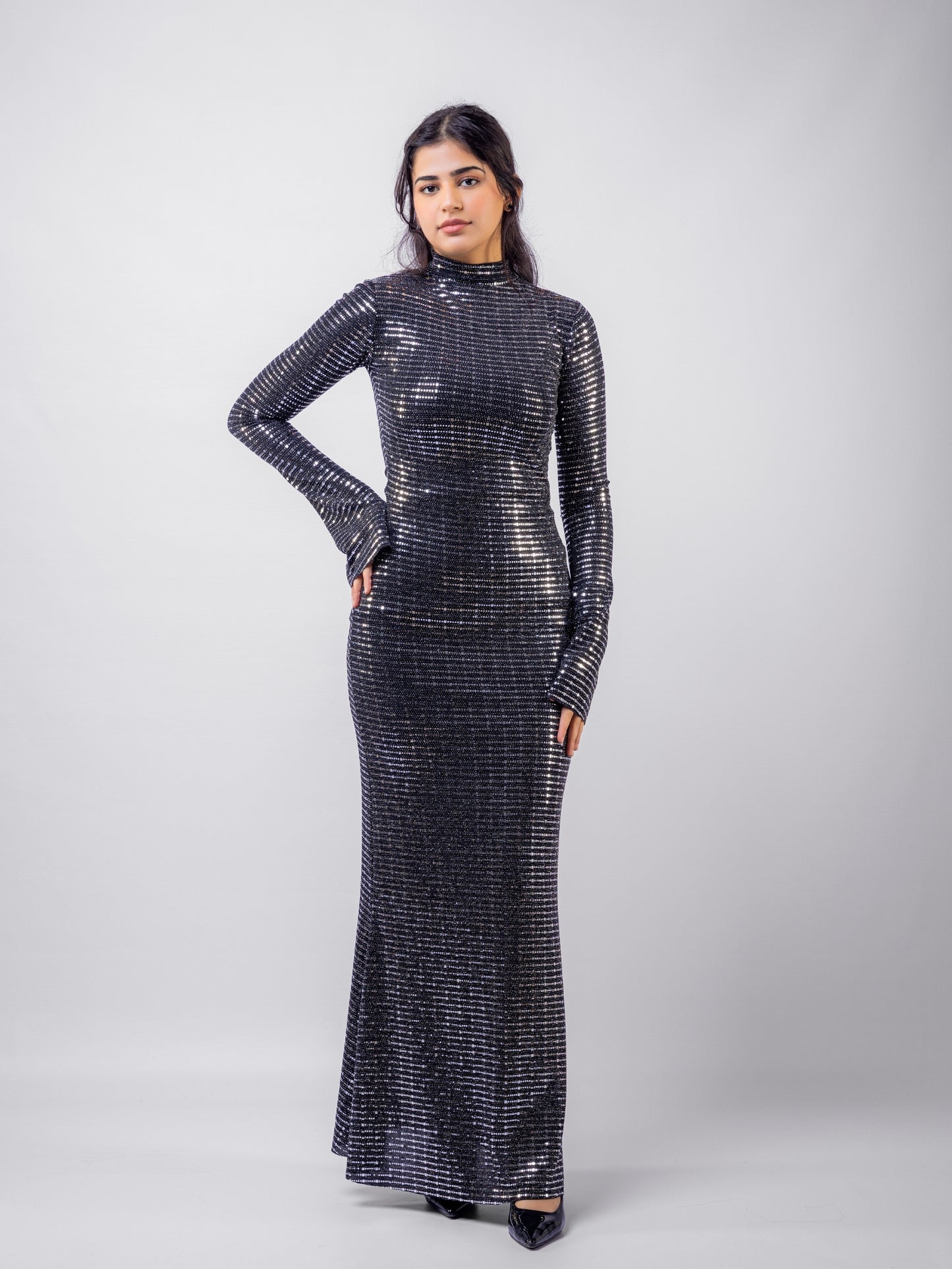Woman wearing a black sequin dress against a white background