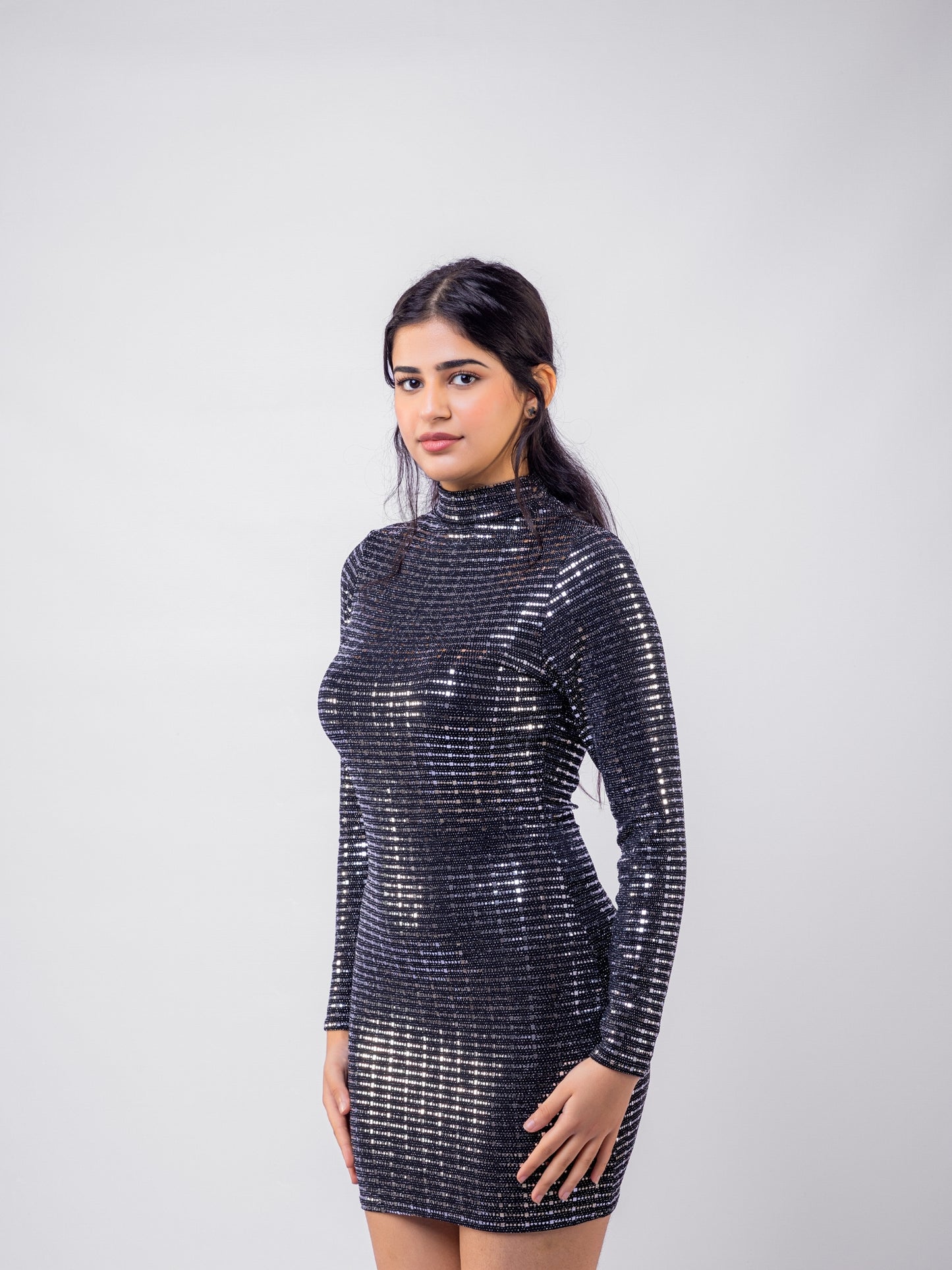 Woman wearing a black sequin dress against a white background