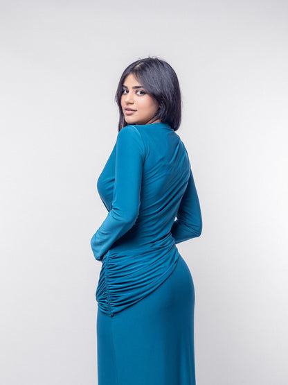 Woman wearing a teal dress against a white background