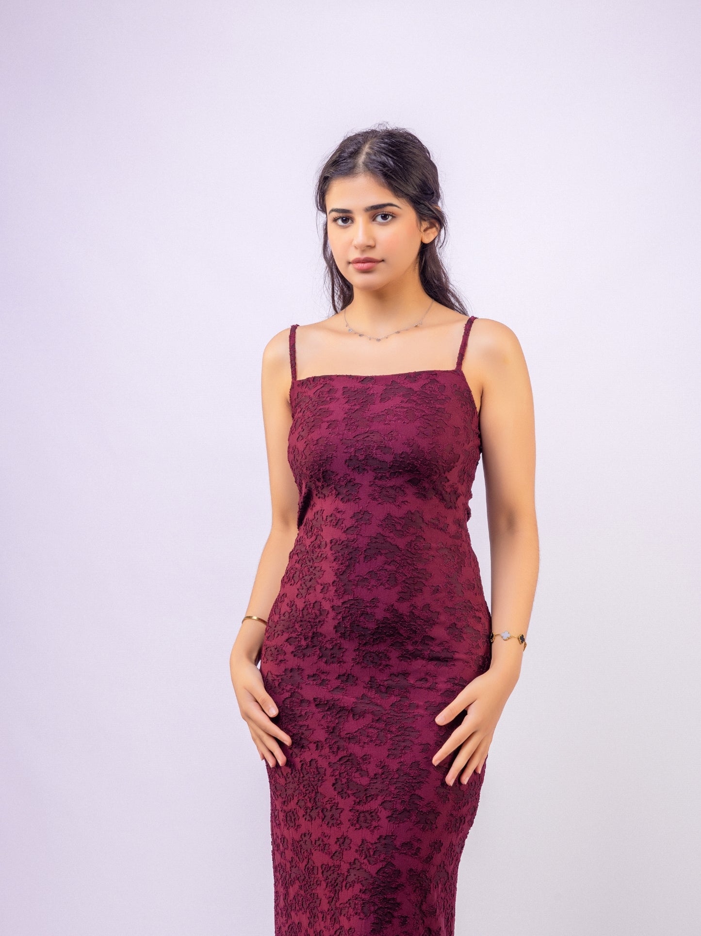Woman wearing a burgundy floral dress against a white background