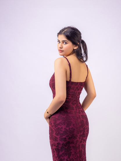 Woman wearing a burgundy lace dress against a white background