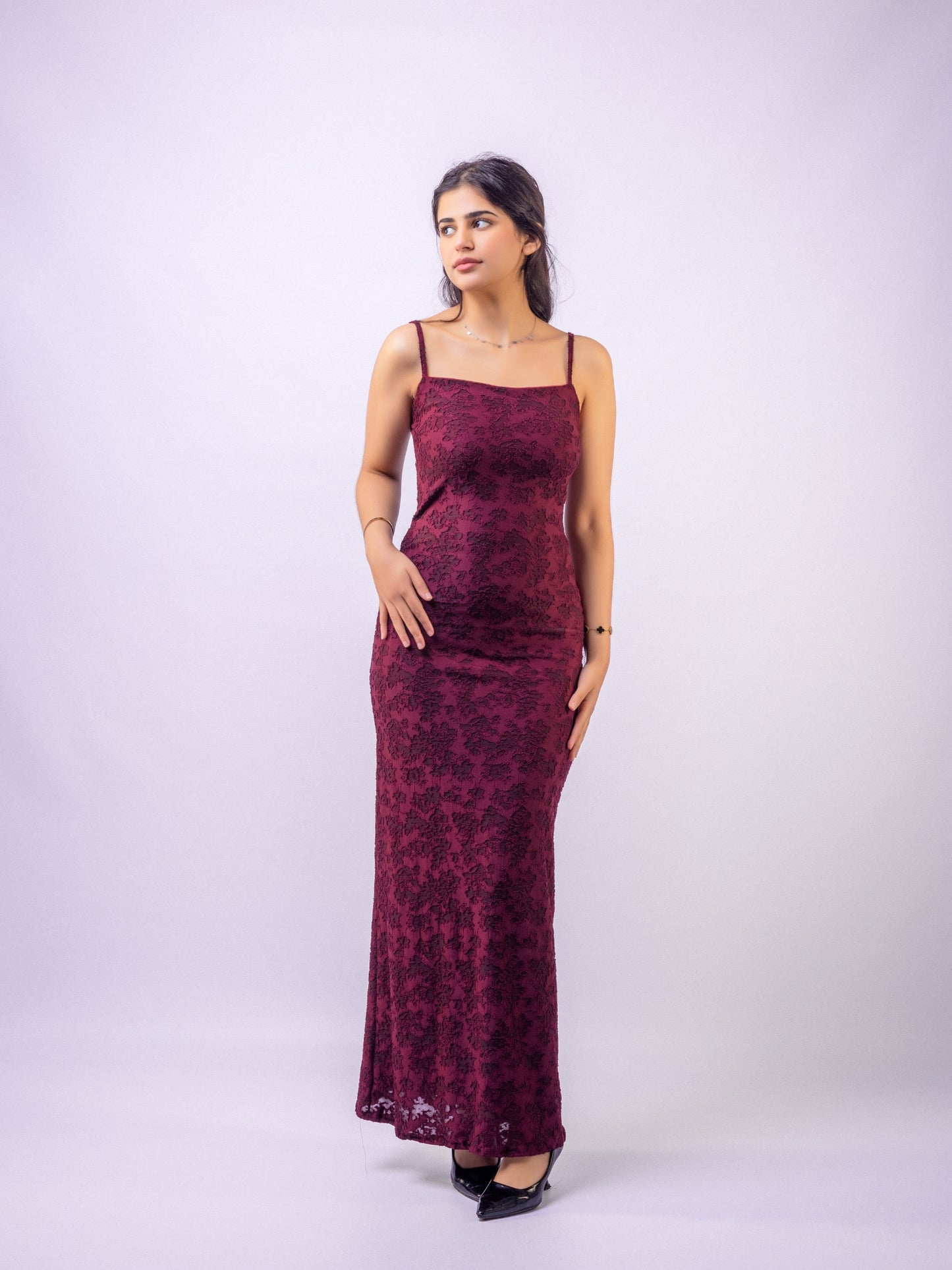 Woman wearing a burgundy floral dress against a white background