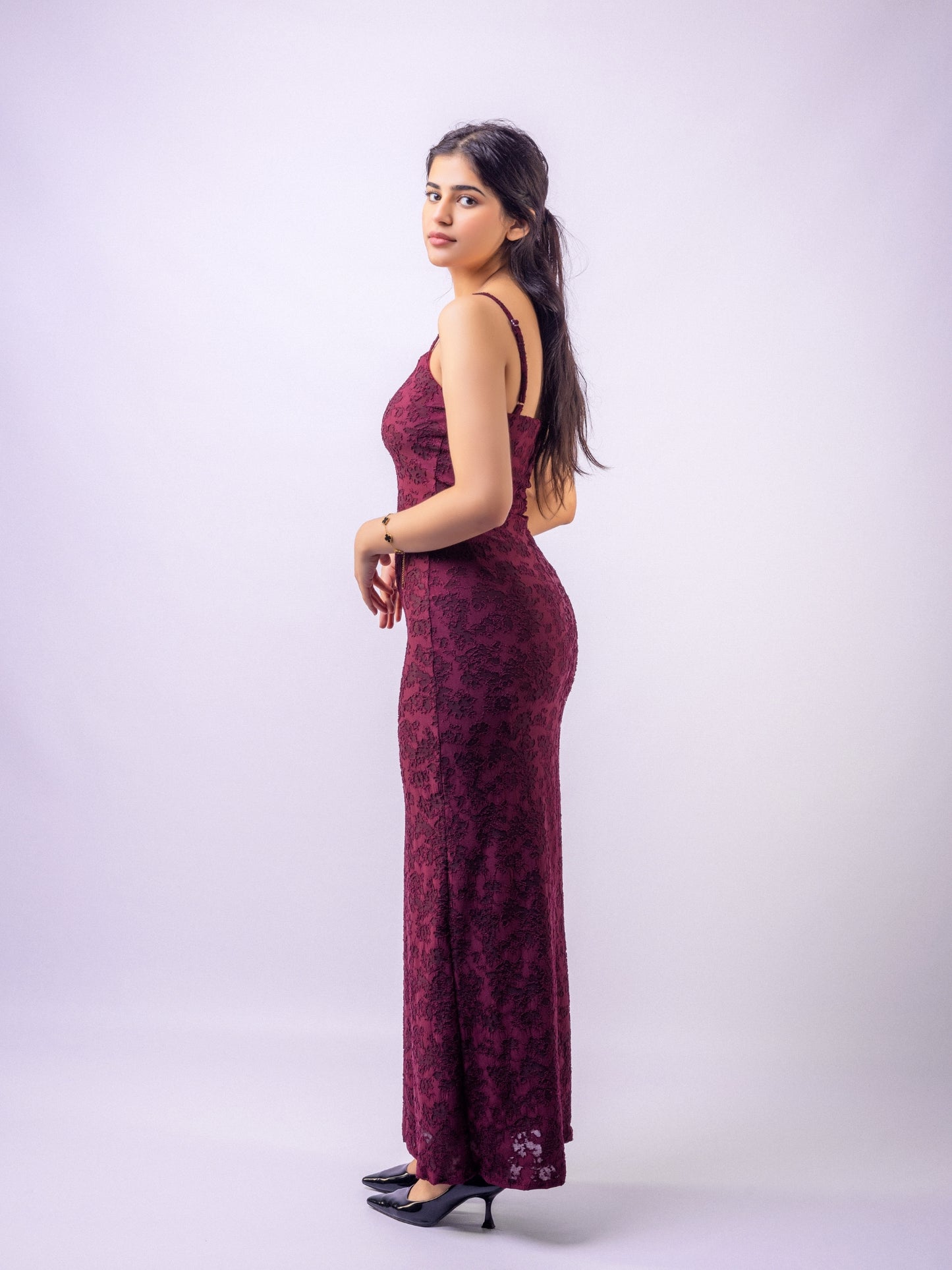 Woman wearing a burgundy floral dress against a white background