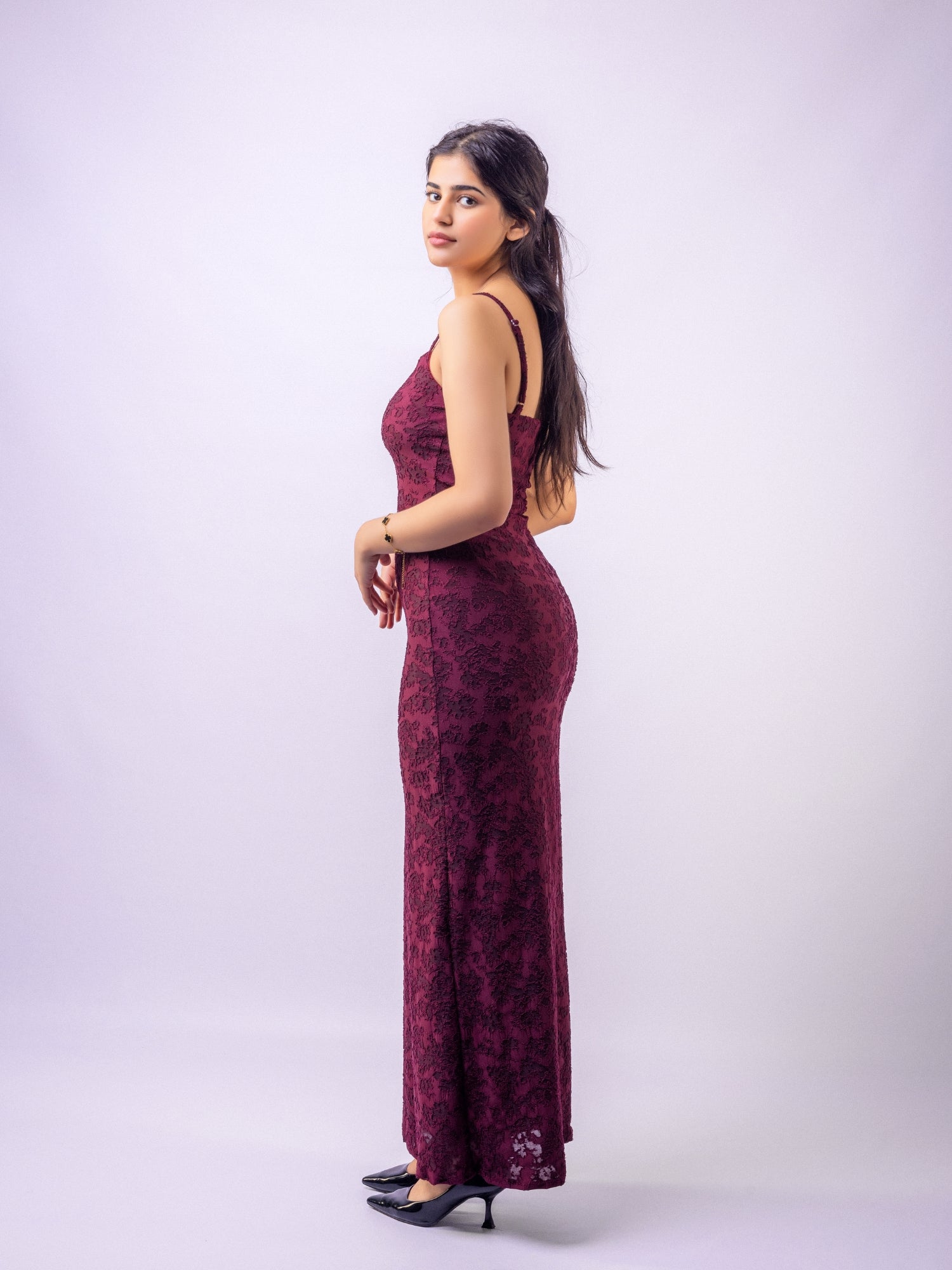 Woman wearing a burgundy floral dress against a white background